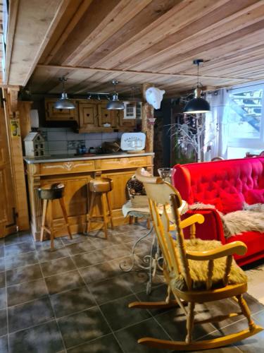 a living room with a red couch and a kitchen at Chez steph et frank in Morez