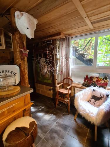 a living room with a large window and a chair at Chez steph et frank in Morez