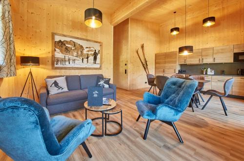 sala de estar con sillas azules y sofá en AlpenParks Chalet & Apartment Steve Lodge Viehhofen, en Viehhofen