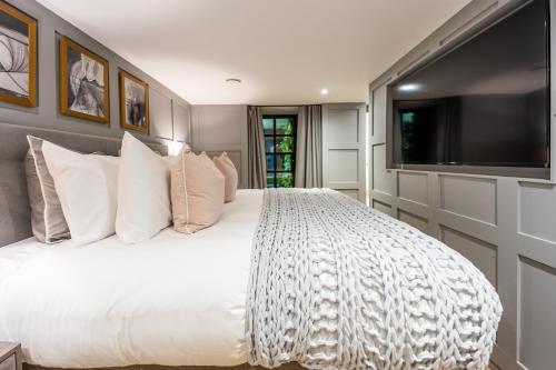 Schlafzimmer mit einem großen weißen Bett und einem Flachbild-TV in der Unterkunft No1 Apartments Edinburgh - New Town in Edinburgh