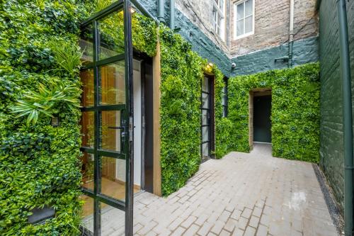 ein mit Efeu bedecktes Gebäude mit einer Glastür in der Unterkunft No1 Apartments Edinburgh - New Town in Edinburgh