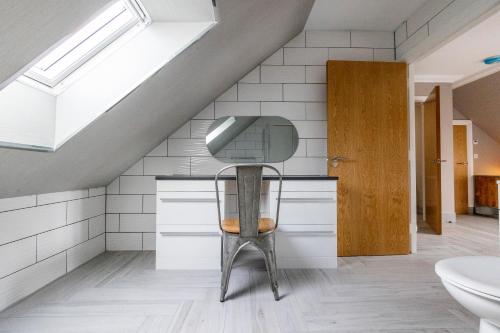 a bathroom with a chair and a sink and a skylight at Westertonhill Lodge 4 Newbuild with Hot Tub Option in Balloch