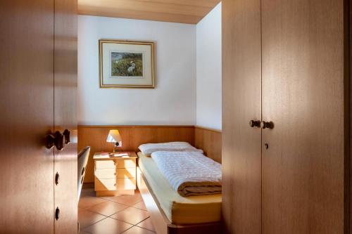 a small bedroom with a bed and a table at Cesa Soramurat Appartamento 9 in Canazei
