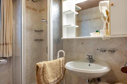 uma casa de banho com um lavatório e um chuveiro em Cesa Soramurat Appartamento 9 em Canazei