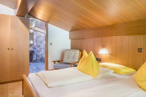 a bedroom with a large bed and a chair at Cesa Soramurat Appartamento 8 in Canazei