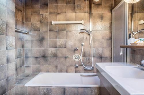 a bathroom with a tub and a sink at Cesa Soramurat Appartamento 8 in Canazei