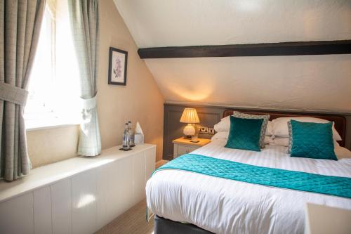 a bedroom with a bed with blue pillows and a window at Haighton Manor - Brunning and Price in Grimsargh