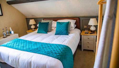 a bedroom with a large bed with blue pillows at Haighton Manor - Brunning and Price in Grimsargh