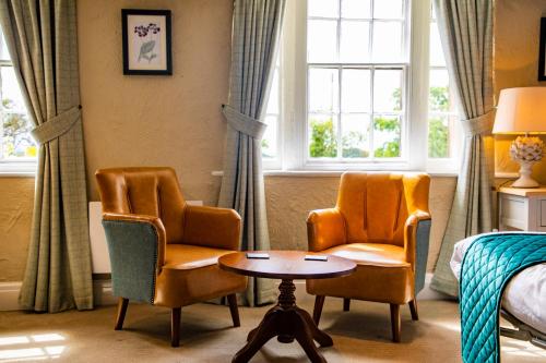 a hotel room with two chairs and a table and a bed at Haighton Manor - Brunning and Price in Grimsargh