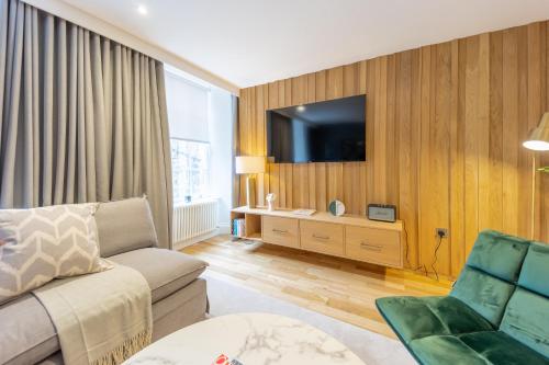 a living room with a couch and a flat screen tv at No1 Apartments Edinburgh - New Town in Edinburgh