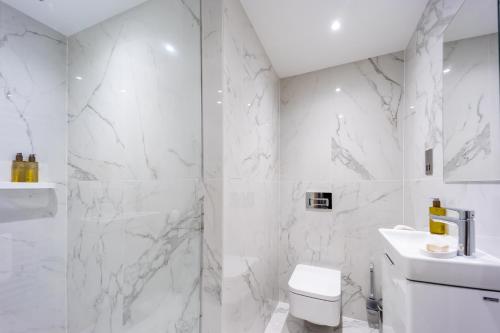 a white bathroom with a shower and a toilet at No1 Apartments Edinburgh - New Town in Edinburgh