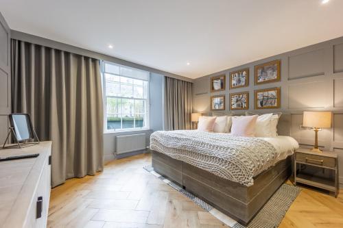 a bedroom with a large bed and a television at No1 Apartments Edinburgh - New Town in Edinburgh