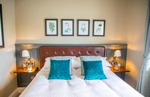 a bedroom with a large bed with blue pillows at Haighton Manor - Brunning and Price in Grimsargh