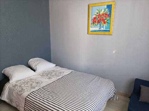 een slaapkamer met een bed met een foto aan de muur bij Chez Nath in Wimille