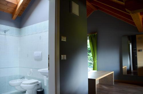 a bathroom with a toilet and a sink at Hotel Villa Argentina Ronzone in Ronzone