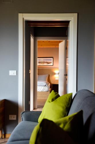 a living room with a blue couch and a bedroom at Hotel Villa Argentina Ronzone in Ronzone
