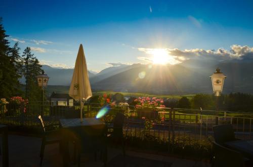 a view of the sunset from a patio with a umbrella at Hotel Villa Argentina Ronzone in Ronzone
