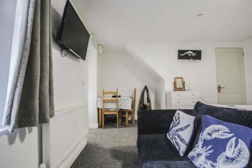 ein Wohnzimmer mit einem Sofa und einem Flachbild-TV in der Unterkunft Self contained studio in Chorley by Lancashire Holiday Lets in Chorley