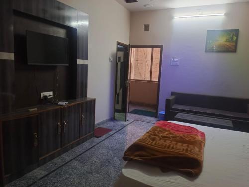 a bedroom with a bed and a flat screen tv at HOTEL ROYAL CHURU in Chūru