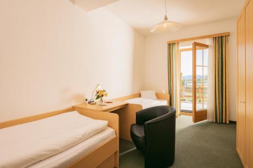 een hotelkamer met een bed, een bureau en een stoel bij Appartementhaus Samson Fanningberg in Weisspriach