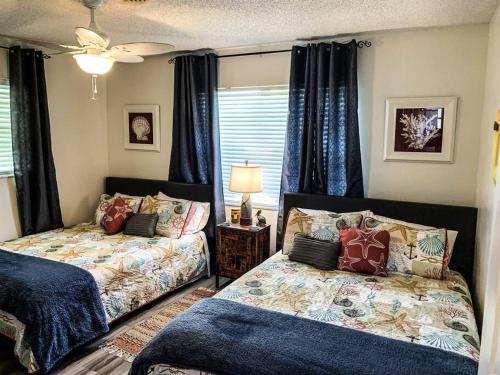- une chambre avec 2 lits et une fenêtre dans l'établissement 3 BDRM cottage w/hot tub, near fishing, beach & DT, à Jensen Beach