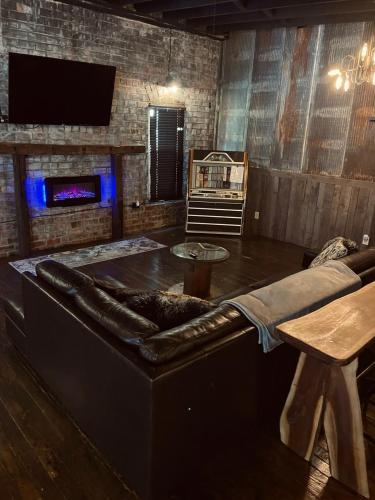 a living room with a leather couch and a table at Hocking Hills Rusty Lofts in Logan