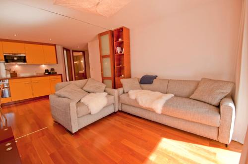 ein Wohnzimmer mit einem Sofa und 2 Stühlen in der Unterkunft Casa D'Amore, Apartment Lyskamm in Zermatt