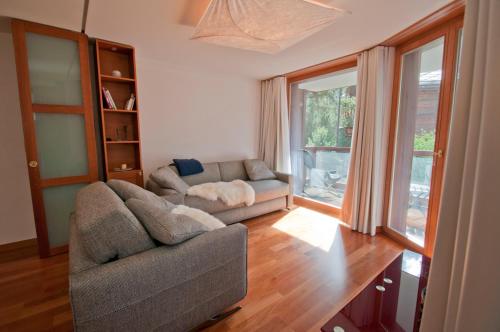 ein Wohnzimmer mit einem Sofa und einem Fenster in der Unterkunft Casa D'Amore, Apartment Lyskamm in Zermatt