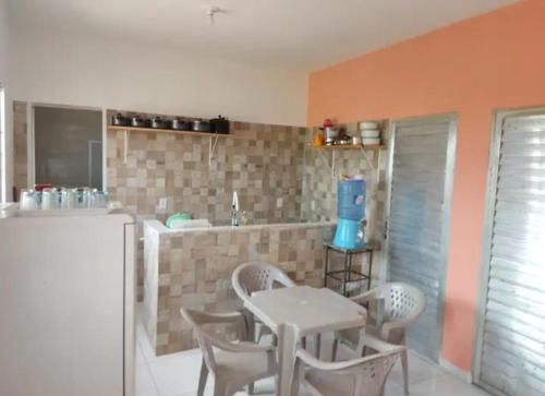 a kitchen with a table and chairs and a refrigerator at APT. CAMINHO DE MOISÉS in Maragogi