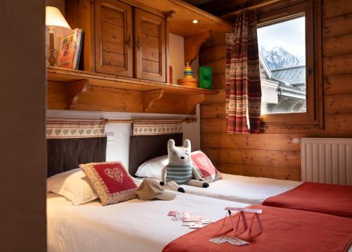 a bedroom with a bed with a stuffed animal on it at Résidence Pierre & Vacances Premium La Ginabelle in Chamonix