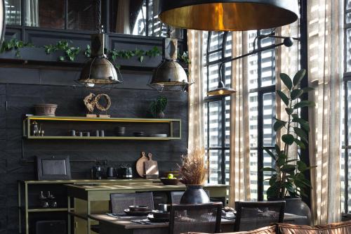 a dining room with a table and chairs and windows at The Bohemian Bali in Canggu