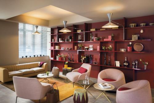 a living room with a couch and chairs and shelves at OKKO Hotels Lyon Centre in Lyon