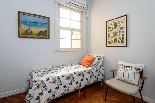 1 dormitorio con cama, ventana y silla en BestHostRio - Leblon 2 Quartos 500 metros da praia, en Río de Janeiro