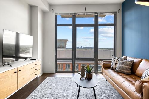 a living room with a couch and a large window at Placemakr Marymount Ballston in Arlington