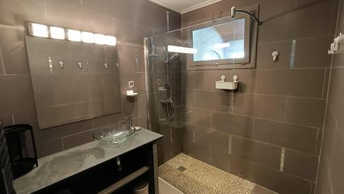 La salle de bains est pourvue d'une douche, d'un lavabo et d'un miroir. dans l'établissement Grande maison familiale avec piscine, proche plage, à Villeneuve-lès-Béziers