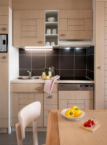 a kitchen with a table with a plate of fruit on it at Pierre & Vacances Premium Résidence de la Plage in Le Crotoy