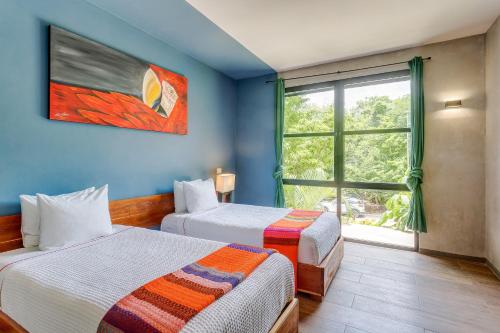 a room with two beds and a window at Chic Suites in the Heart of Tulum by Stella Rentals in Tulum