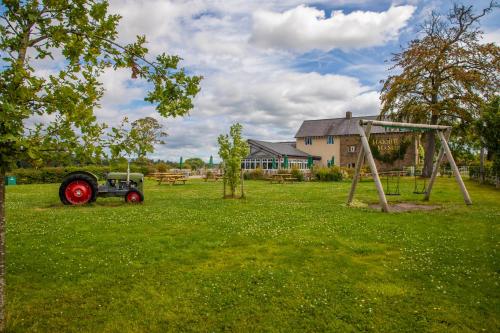 an old tractor and a swing set in a field at Haighton Manor - Brunning and Price in Grimsargh