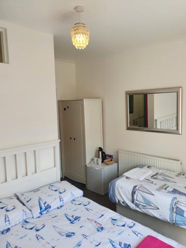 Tempat tidur dalam kamar di SINGER HOUSE BEACH , SLEEPS 6, self GARDEN Always Happy to Help you ,24 Hour Reception , PERFECT for the ELDERLY GROUND FLOOR LARGE GARDEN 2 BEDROOM APARTMENT, PRIVATE GATE & PRIVATE CAR SPACE & KITCHEN , LARGE WALK IN SHOWER , Opposite PAIGNTON PIER