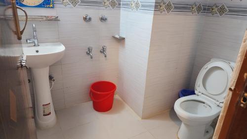 a small bathroom with a toilet and a sink at Elite Cox's Resort in Cox's Bazar