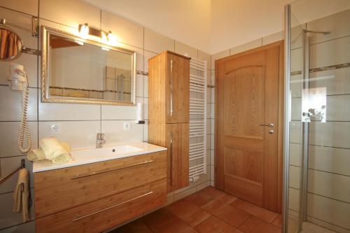 a bathroom with a sink and a mirror and a shower at Cafe Wastelbauerhof - Urlaub auf dem Bauernhof in Bernau am Chiemsee