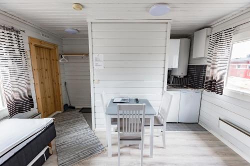 una pequeña cocina con una mesa y una cama en una habitación en Crow Creek Cabins en Inari