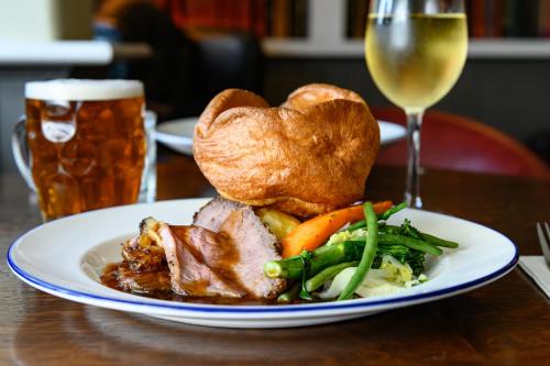 a plate of food with meat and vegetables and a glass of beer at Haighton Manor - Brunning and Price in Grimsargh