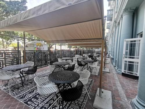 a patio with tables and chairs on a building at ONOMO Hotel Cape Town – Inn On The Square in Cape Town