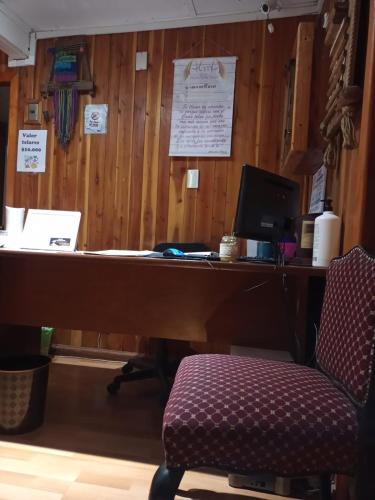 an office with a desk with a computer and a chair at Hostal Valentino in Villarrica