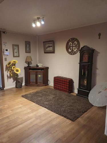 a living room with a clock and a rug at Hostal Valentino in Villarrica