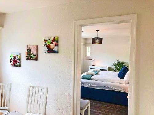 a bedroom with a bed with two pictures on the wall at INN JOY Apartments - Rorschach mit Panoramasicht in Rorschach
