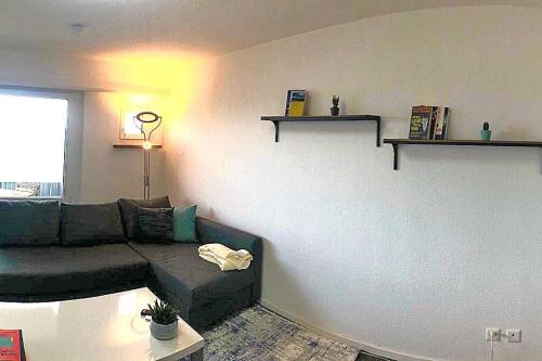 a living room with a couch and shelves on the wall at INN JOY Apartments - Rorschach mit Panoramasicht in Rorschach