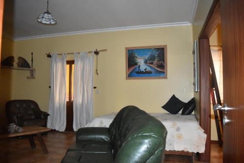 a living room with a leather couch and a table at Casa na Serra da Estrela in Melo