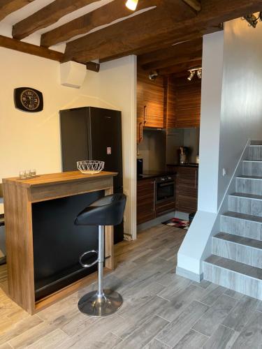 une cuisine avec un comptoir et un tabouret dans une pièce dans l'établissement L’Atypique, à Villers-sur-Mer